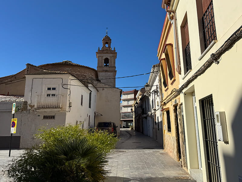 Тихая улица и церковь в исторической части района Poblados del Oeste (Валенсия). How-To Spain
