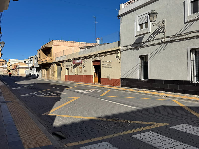 Широкая улица с невысокой застройкой и традиционными фасадами в районе Poblados del Oeste (Валенсия). How-To Spain