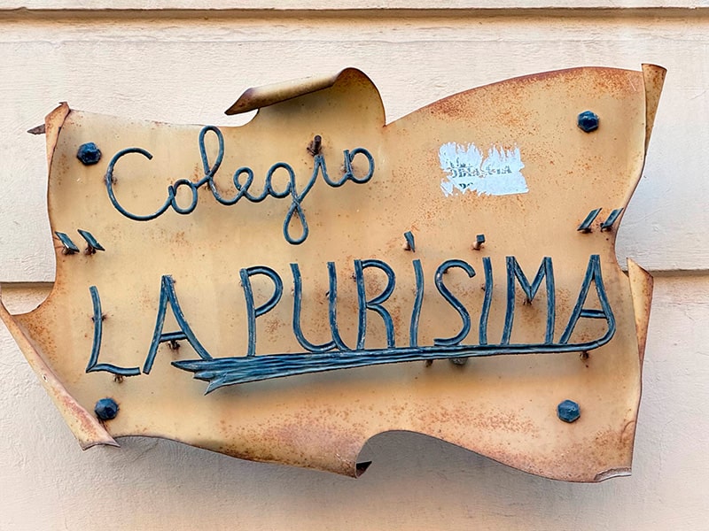 Металлическая табличка на стене с надписью Colegio &ldquo;La Pur&iacute;sima&rdquo; в районе Кабаньял (Валенсия).