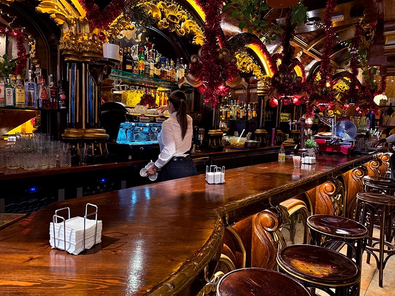 Барная стойка ресторана La Catedral, украшенная к Рождеству, бармен готовит кофе