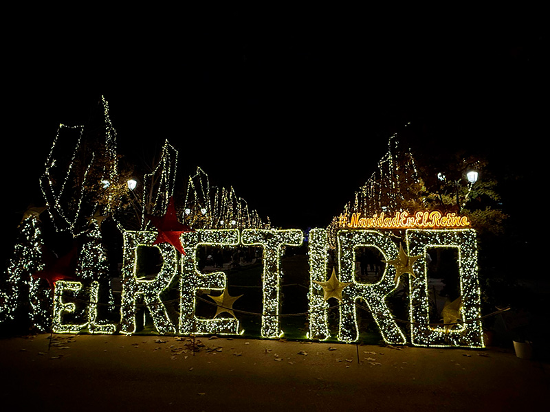 Рождественская световая инсталляция «EL RETIRO» в парке Parque del Retiro в Мадриде ночью: гирлянды на деревьях и праздничная подсветка