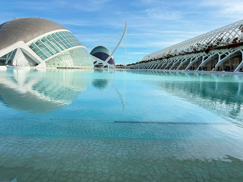 Город искусств и наук в районе Quatre Carreres в Валенсии, футуристические белые здания, отражающиеся в бирюзовой воде бассейна