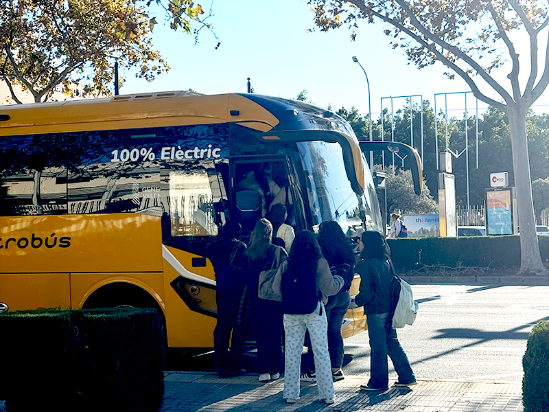 Группа студентов садится в жёлтый электрический автобус (100% Électric) на остановке в районе Algirós, Валенсия.