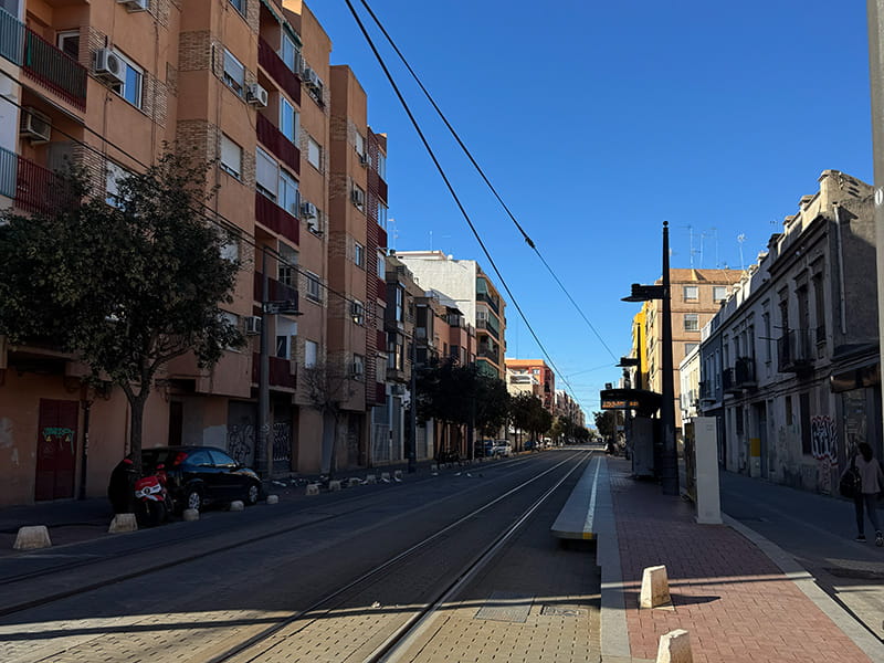 Трамвайные пути и остановка на тихой улице с жилыми домами в районе Беникалап, Валенсия, Испания