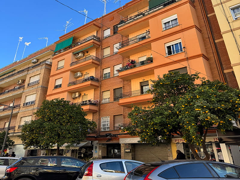 Жилой дом с балконами и апельсиновыми деревьями вдоль улицы в районе Беникалап, Валенсия, Испания