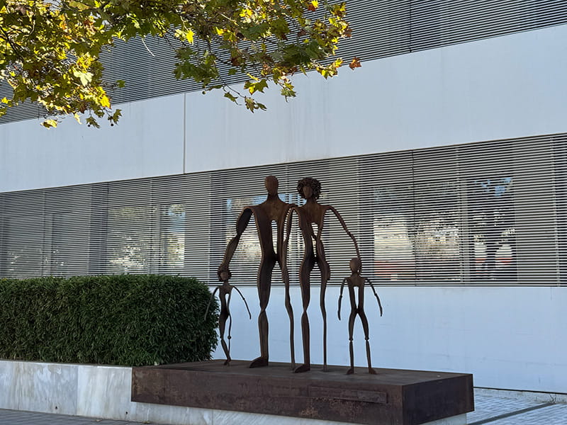 Металлическая скульптура семьи на постаменте у здания Casa Caridad в Валенсии, Испания