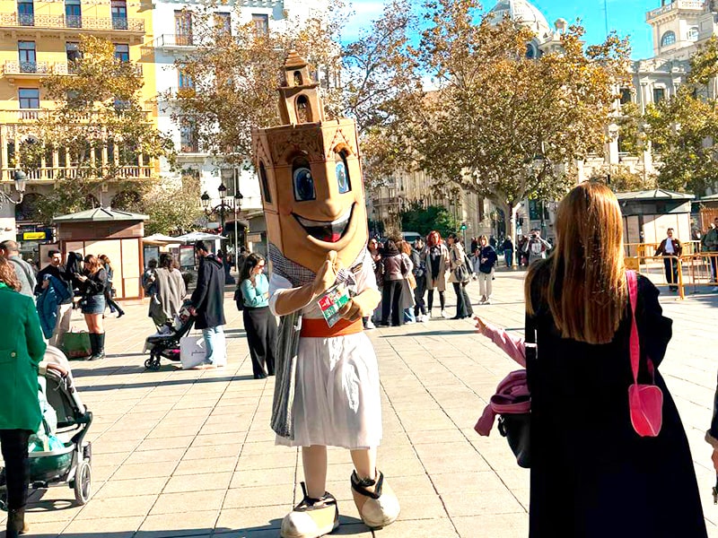 Промоутер в костюме в виде башни Валенсии на рождественской площади Ayuntamiento