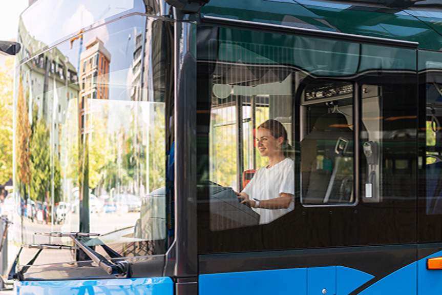 Женщина за рулем экологичного городского автобуса